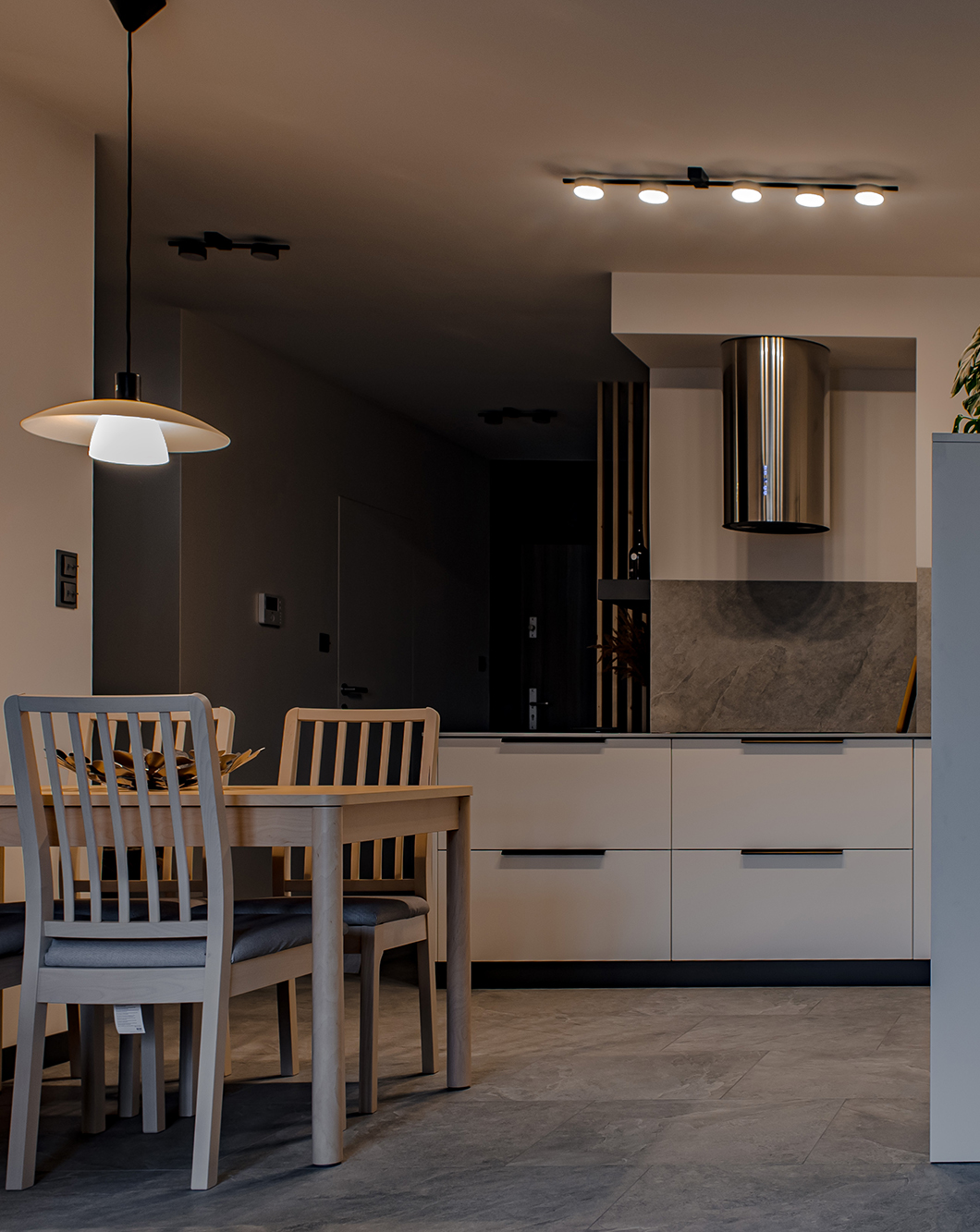 Drewniane elementy, które pięknie kontrastują z chłodnymi szarościami, dodały do tego wnętrza ciepła i naturalności.